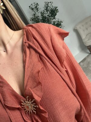 Blouse terracotta avec bijou soleil doré