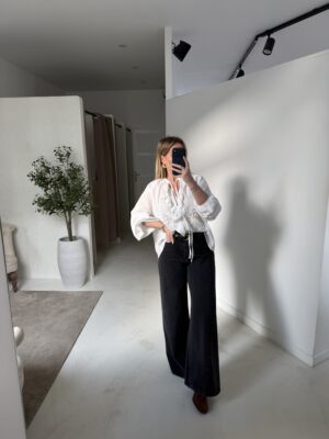 Blouse blanche à volants et manches amples ajourées