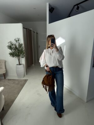 Blouse blanche ajourée sur la poitrine et aux poignets